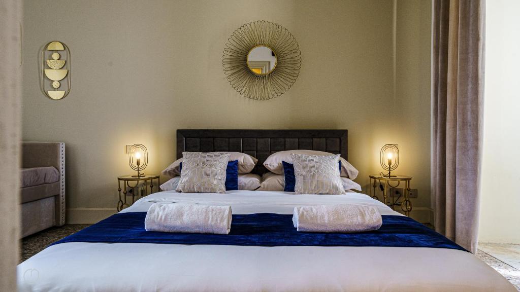 1 dormitorio con 1 cama grande con almohadas y espejo en Palazzo Nouveau, en Catania