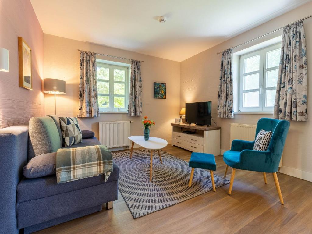 a living room with a couch and a table at Feriendorf Rugana - Komfortplus Appartement mit 1 Schlafzimmer und Terrasse B19 in Dranske