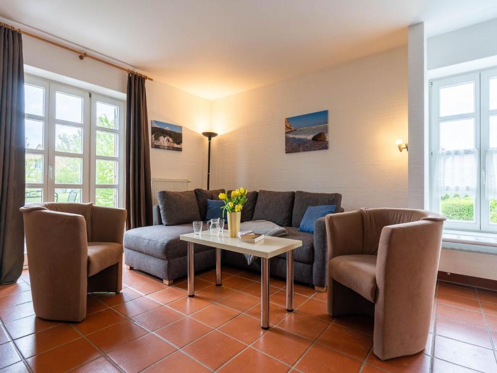 ein Wohnzimmer mit einer Couch und einem Tisch und Stühlen in der Unterkunft Feriendorf Rugana - Klassik Appartement mit 2 Schlafzimmern und Terrasse D01 in Dranske