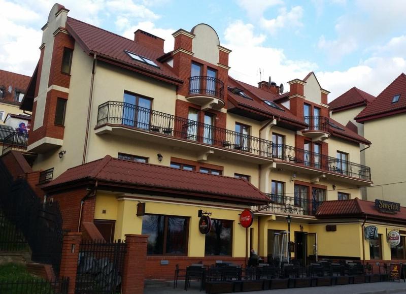 a large building with balconies on the side of it at Apartamenty Smętek in Ełk