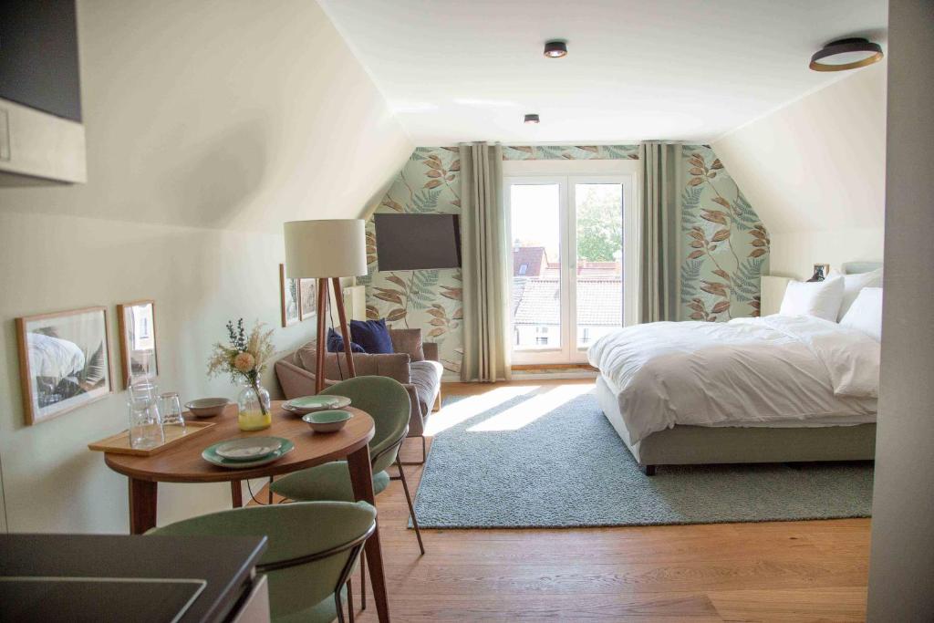 - une chambre avec un lit, une table et des chaises dans l'établissement 21rooms, à Ingolstadt