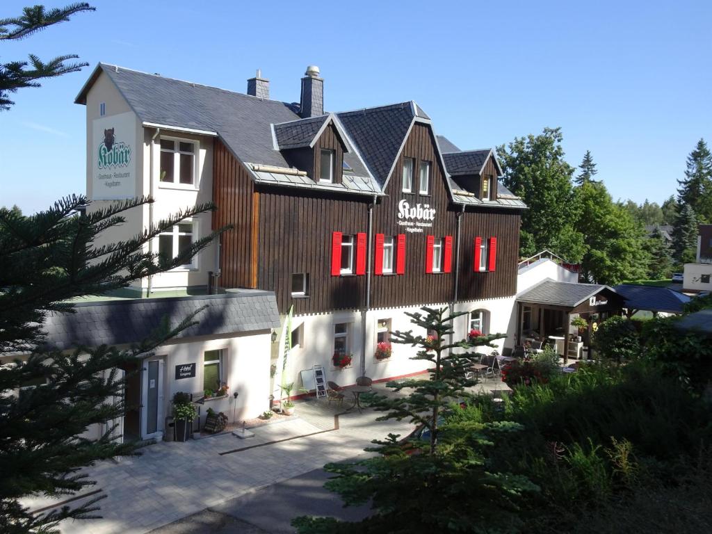um grande edifício com persianas vermelhas em Gasthaus Kobär em Kurort Altenberg