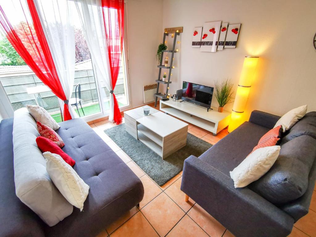 sala de estar con 2 sofás y TV en Léman Holidays - Le Coquelicot, en Thonon-les-Bains