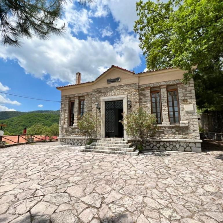 an exterior view of a stone house with a driveway at Abeliona Guesthouse in Ambeliona