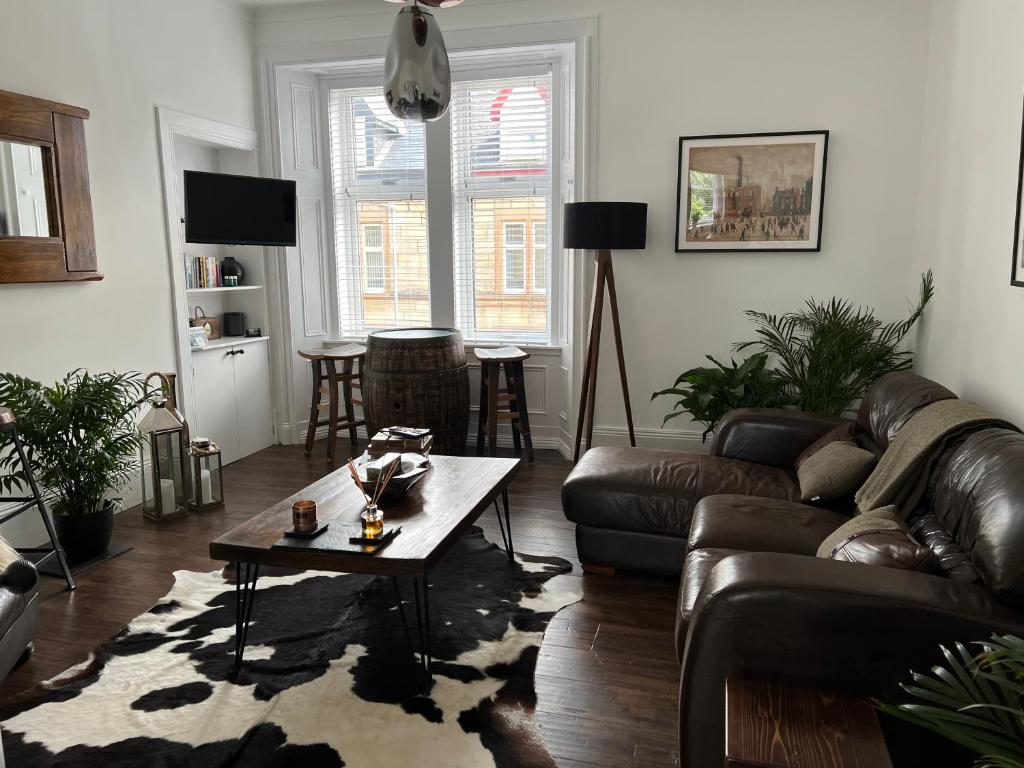 a living room with a couch and a coffee table at The Lowry .. Where elegance meets Luxury! in Oban