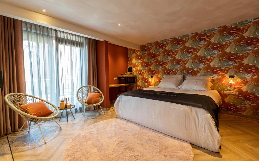 多克姆的住宿－Boutiquehotel Dokkum，一间卧室配有一张大床和两把椅子