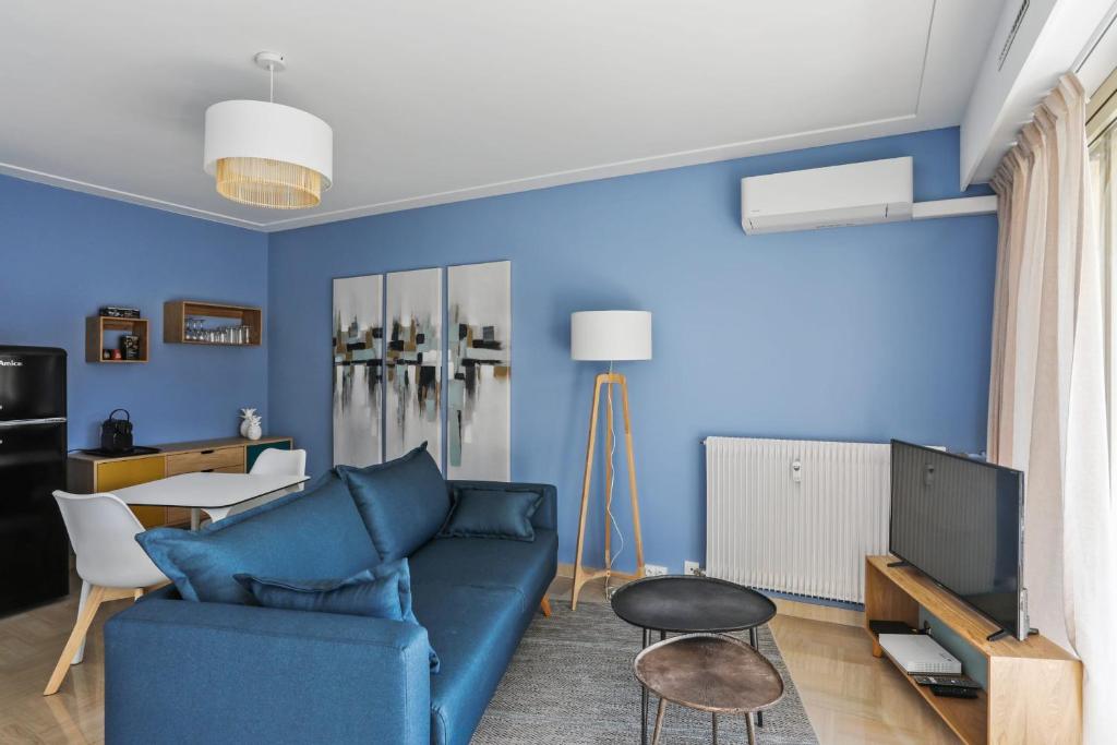 - un salon avec des murs bleus et un canapé bleu dans l'établissement Superbe appartement avec terrasse et parking - Antibes - Welkeys, à Antibes