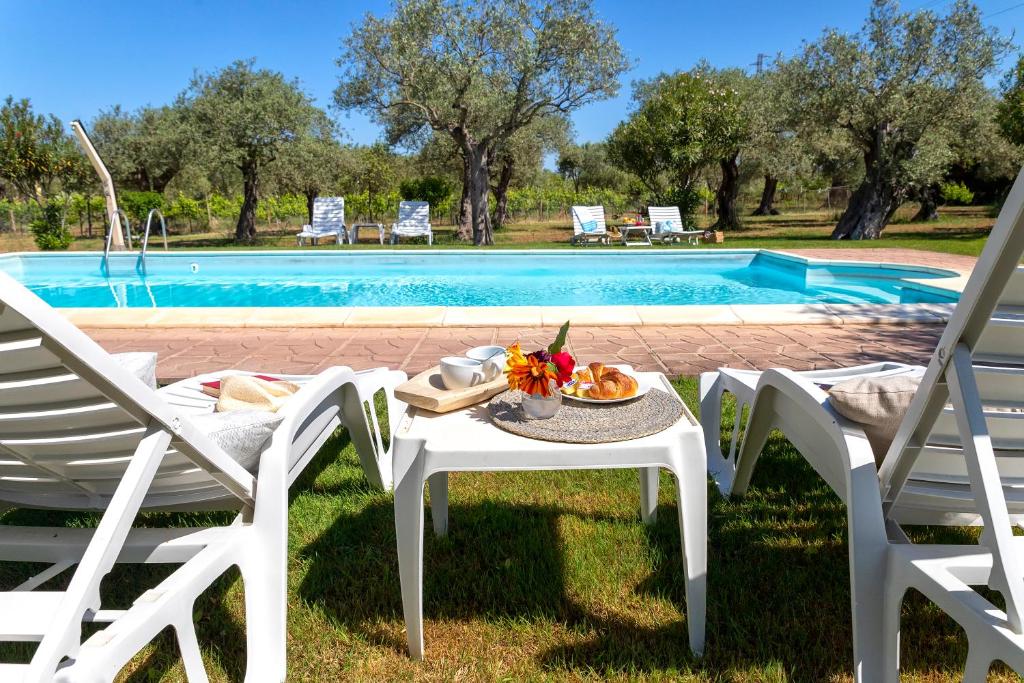 a table and chairs next to a swimming pool at Villa Grazia in Alghero