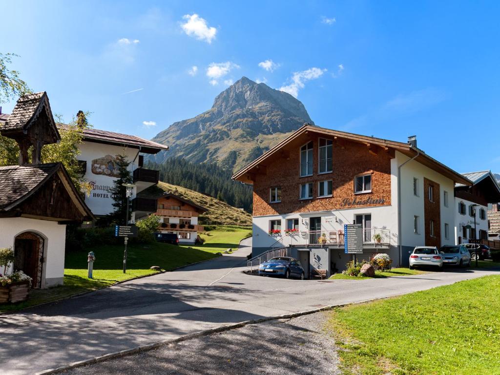 a street in a village with a mountain in the background at Haus Sebastian in Lech am Arlberg