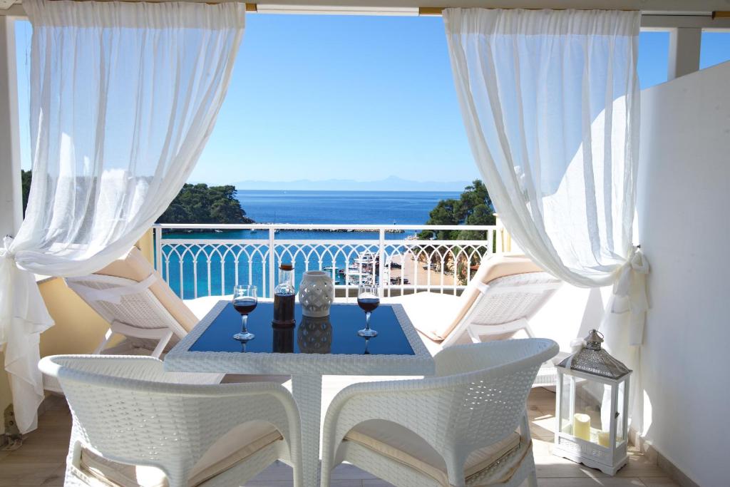 a table and chairs on a balcony with a view of the ocean at Pension Votsi in Votsi