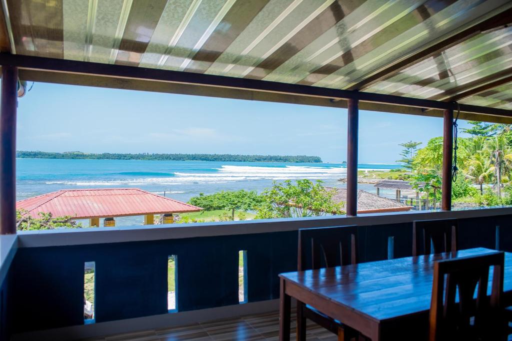 a dining room with a table and a view of the ocean at Yuni Surf House in Lagudri