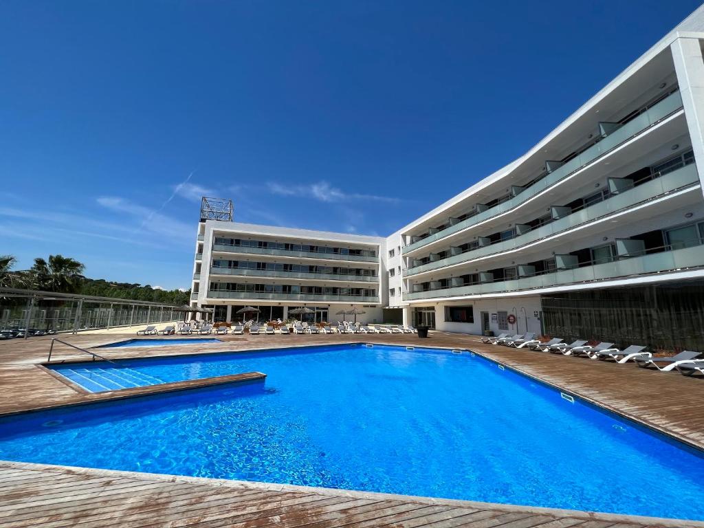a swimming pool in front of a building at RVHotels Nautic Park in Platja d'Aro