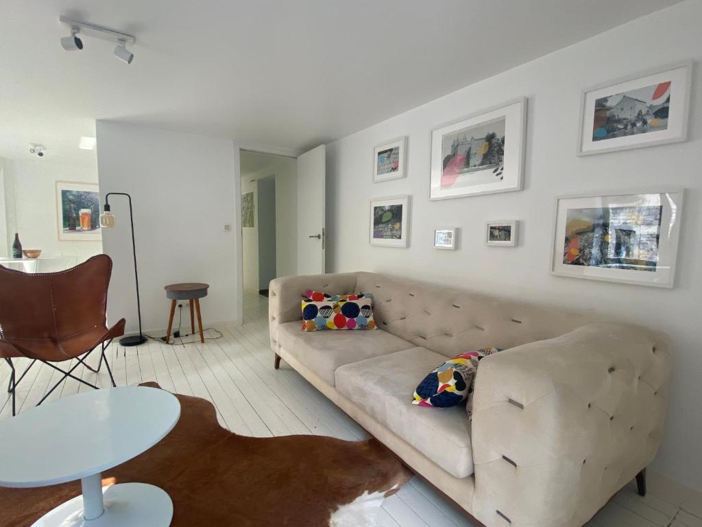 ein Wohnzimmer mit einem Sofa und einem Tisch in der Unterkunft L'atelier de Durbuy in Durbuy