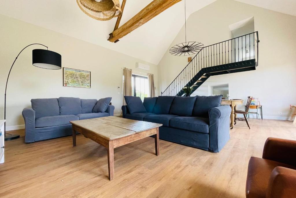 a living room with blue couches and a table at La grange du Pigeonnier authenticity and gentleness 10 minutes from Tours in La Riche