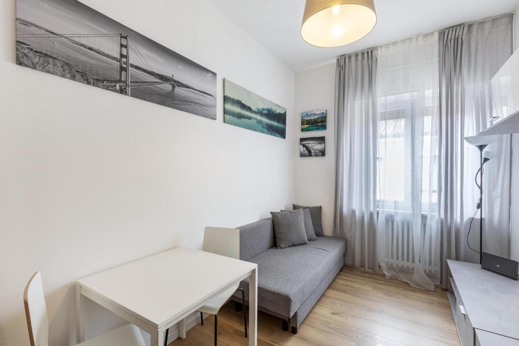 salon z kanapą i stołem w obiekcie Queen East Verona Appartamenti w Weronie
