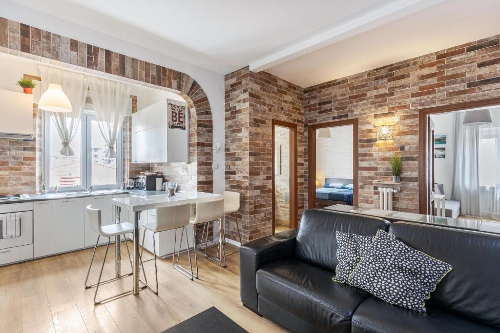 salon z czarną skórzaną kanapą i kuchnią w obiekcie Queen East Verona Appartamenti w Weronie