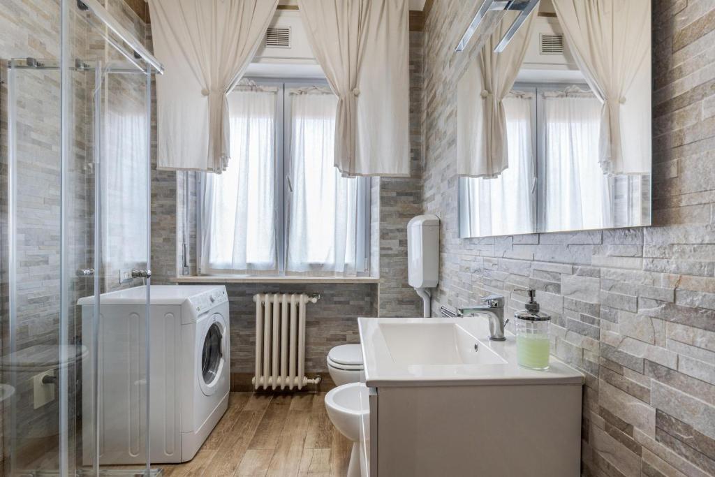 łazienka z umywalką i pralką w obiekcie Queen East Verona Appartamenti w Weronie