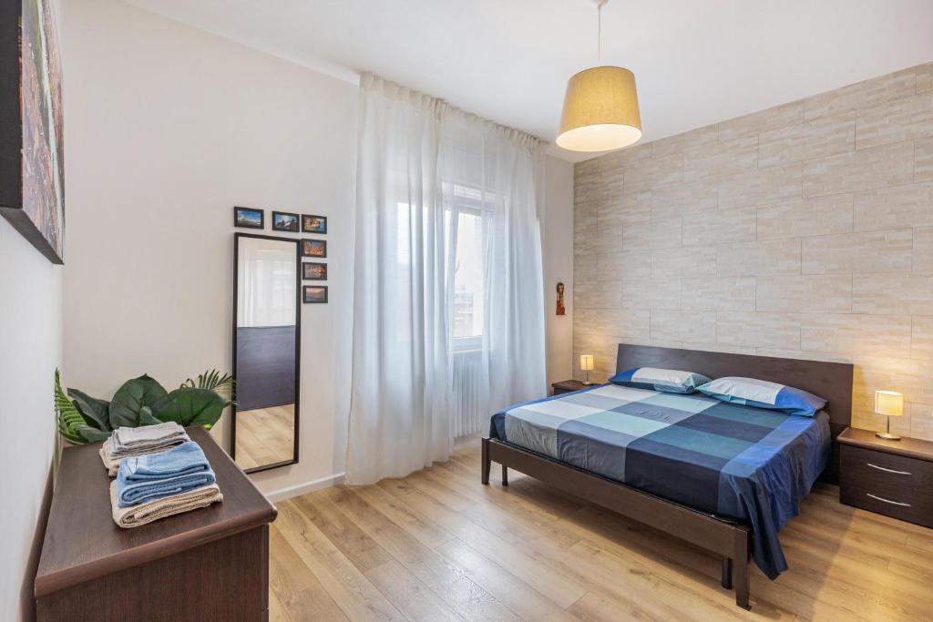 sypialnia z łóżkiem z niebieską kołdrą w obiekcie Queen East Verona Appartamenti w Weronie