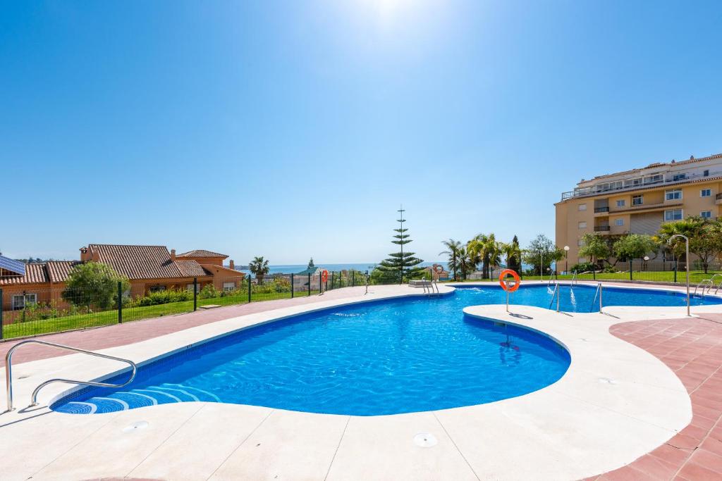 a swimming pool with blue water in a building at Modern Apartment in Jardin Botanico in La Cala de Mijas