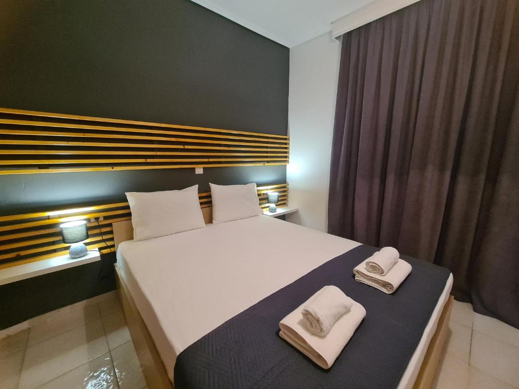 een slaapkamer met een groot bed en handdoeken bij Apartment in the heart of the city 5A in Larisa