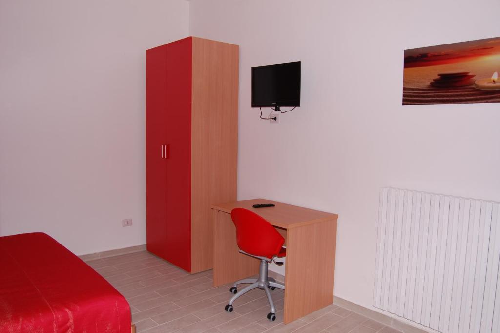 a bedroom with a desk and a bed and a red cabinet at B&B Fenix in Trani