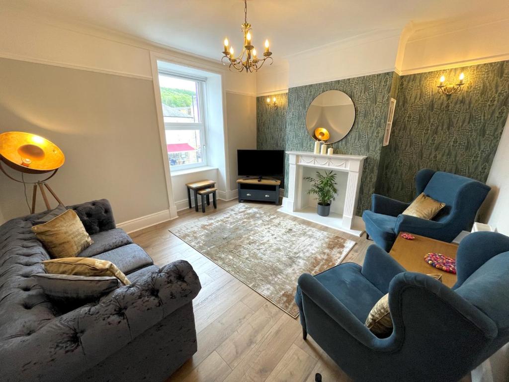 a living room with a couch and chairs and a fireplace at Pass the Keys Beautifully Presented 3BR Luxury Apartment in Kirkcudbright