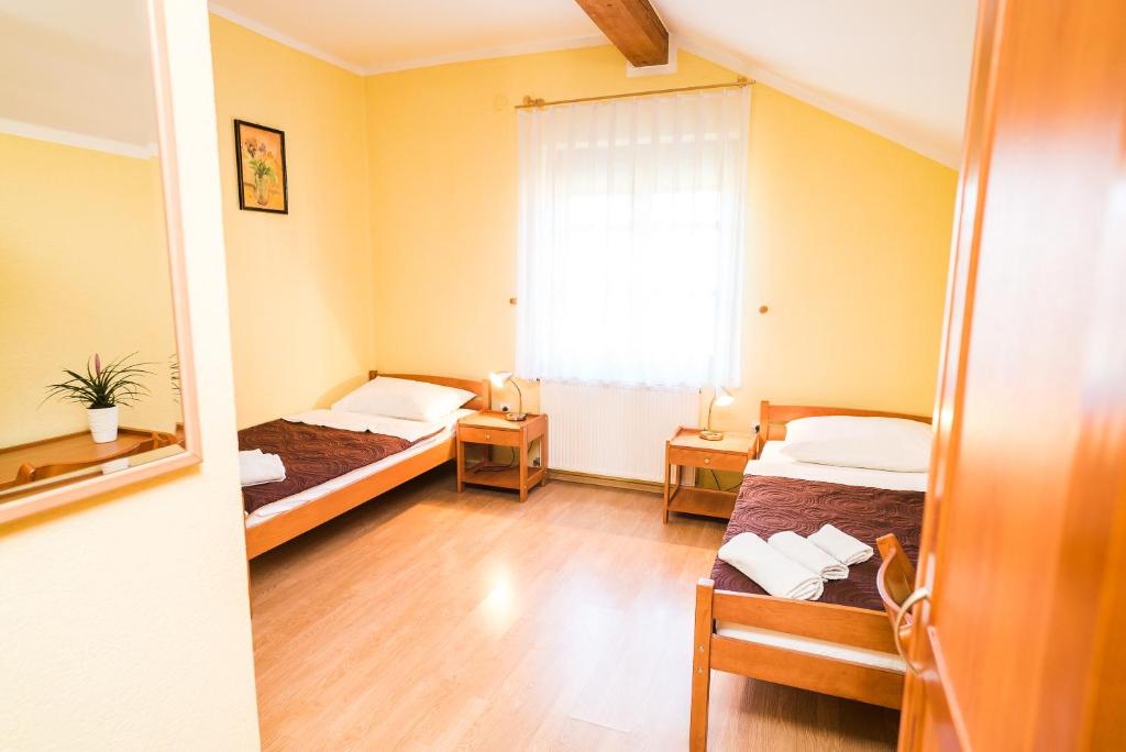 een kleine kamer met 2 bedden en een raam bij Hotel Vincentinum Novigrad na Dobri in Duga Resa