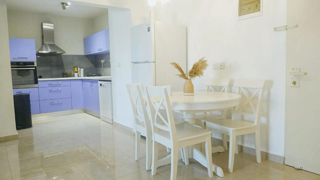 - une cuisine blanche avec une table et des chaises blanches dans l'établissement Eilat - Pleasant Stay, à Eilat