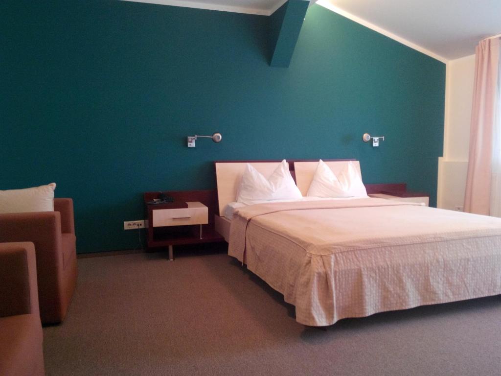 a bedroom with a large bed with a green wall at Hotel Baneasa Parc in Bucharest