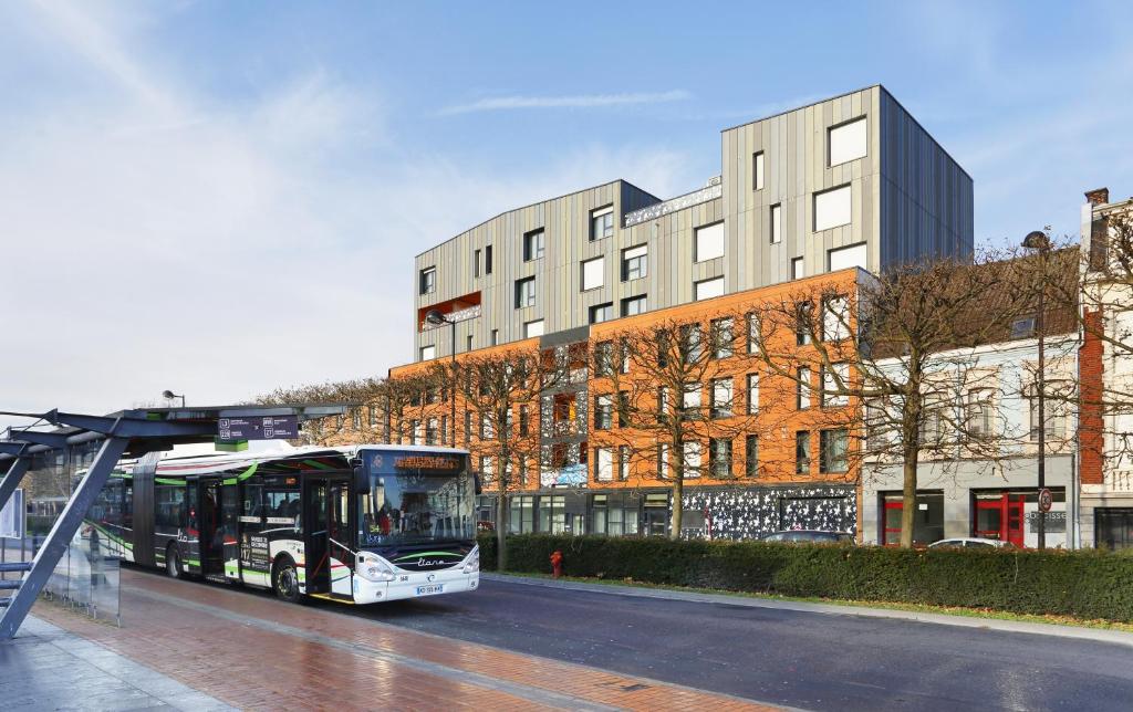 a bus parked at a bus stop in front of a building at Résidence Néméa Roubaix in Roubaix