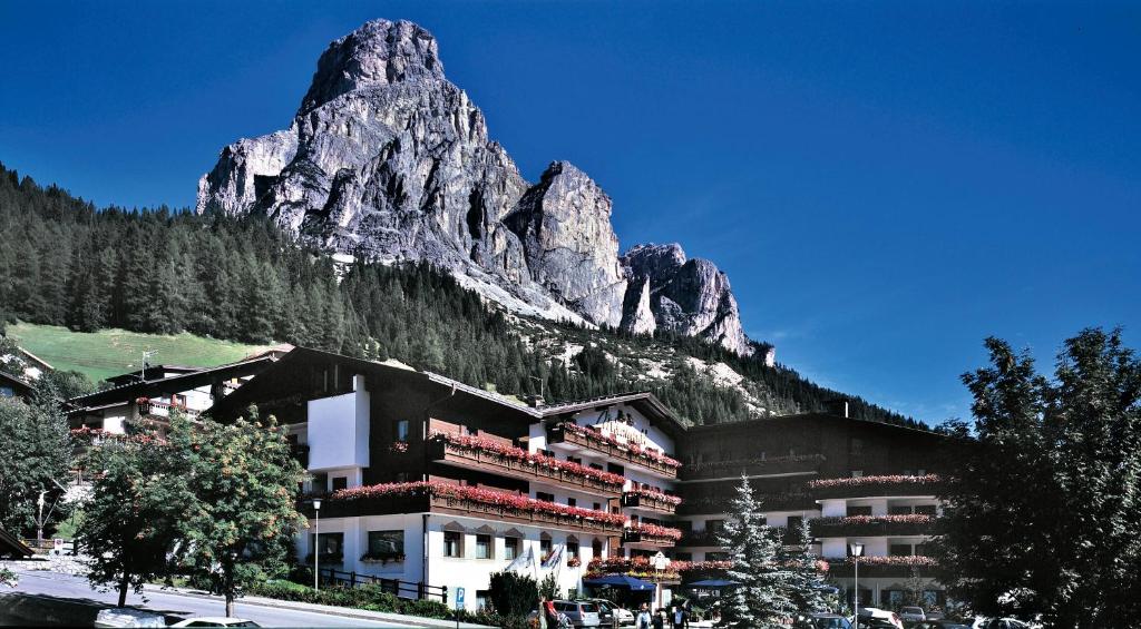 ein Hotel mit einem Berg im Hintergrund in der Unterkunft Hotel Miramonti Corvara in Kurfar