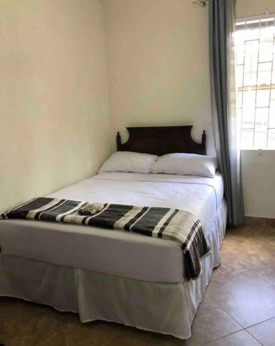 a bedroom with a bed in a room with a window at Kelly's Studio Apartment - Rental near Airport, Amenities and Bus Route in Saint Philip