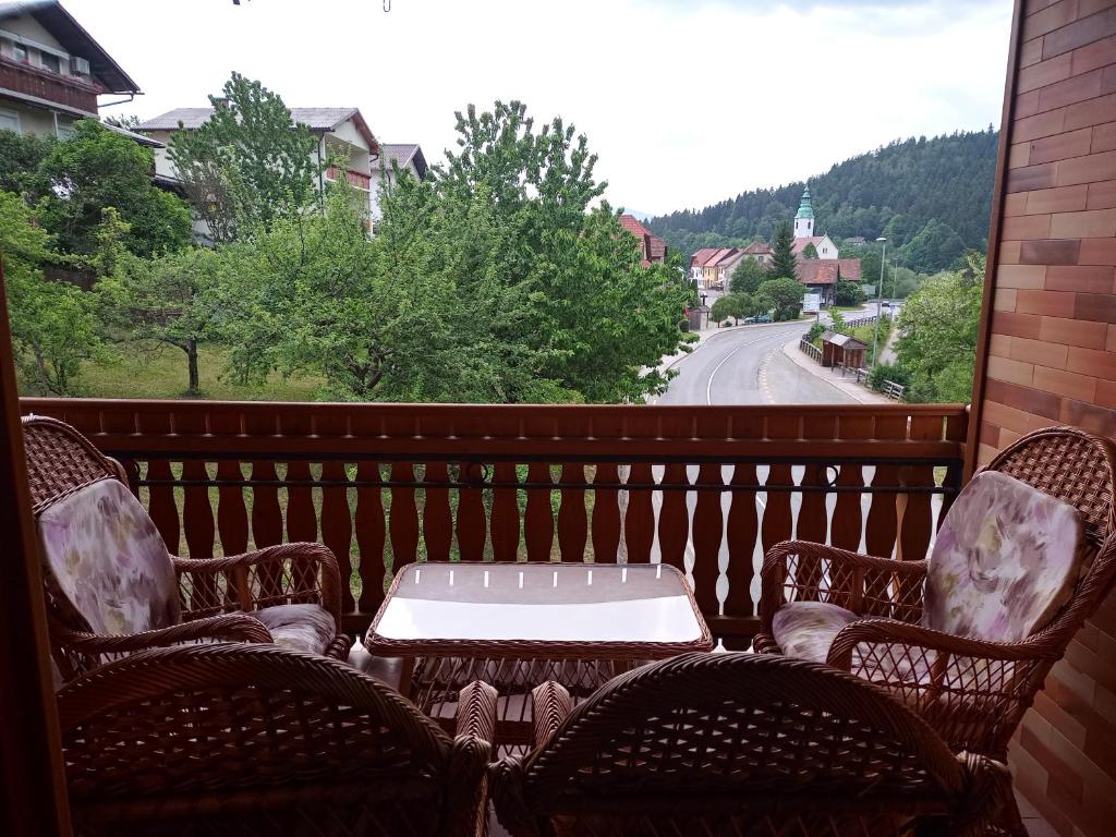 a patio with a table and chairs on a balcony at Lahova hiša in Ljubno