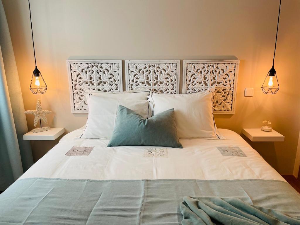 1 dormitorio con 1 cama con 2 almohadas en Fantástico apartamento T2 a 2min do acesso à praia CozyIn Cabanas, en Cabanas de Tavira