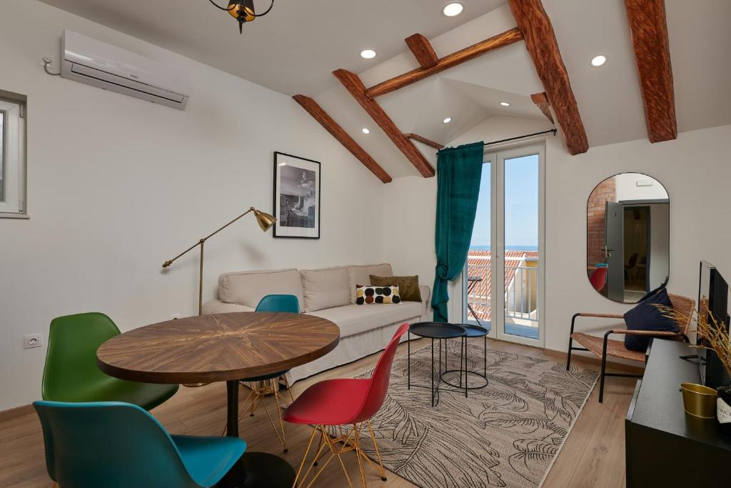 a living room with a table and chairs and a couch at Apartments Maruna in Cavtat