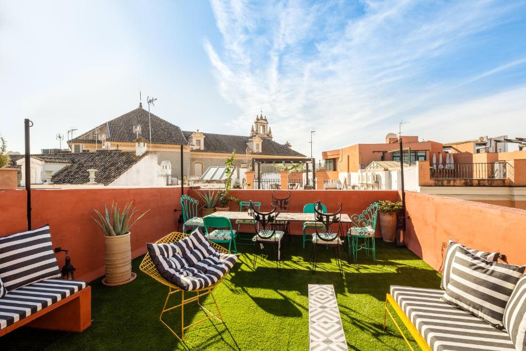 een patio met stoelen en een tafel op een dak bij Veoapartment Casa Alfonso XII in Sevilla