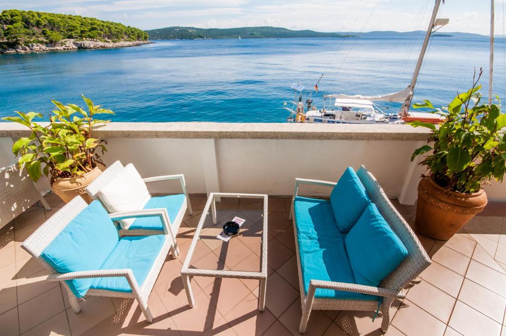 a balcony with two chairs and a view of the water at Hotel Agava in Božava