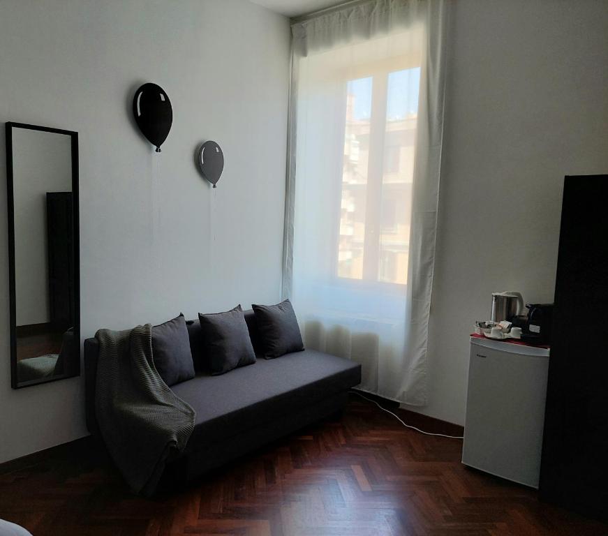 a living room with a couch in front of a window at Pepe's Place - Re di Roma in Rome