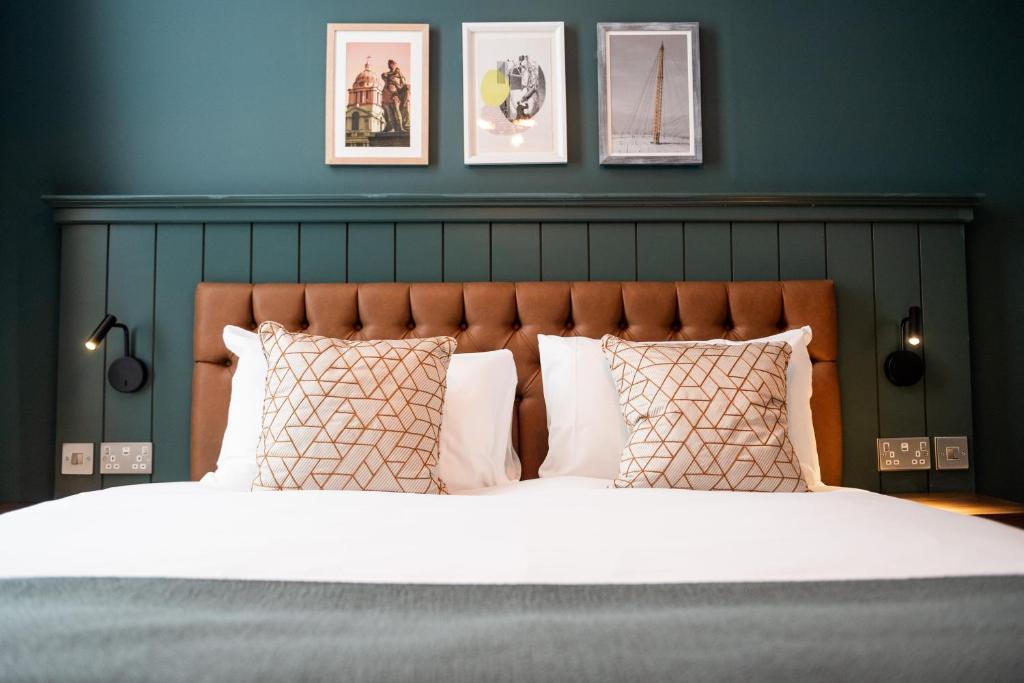 a bedroom with a large bed with white sheets and pillows at The Mitre by Innkeeper's Collection in London