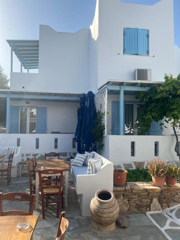 a patio with a table and chairs and a building at Argo in Antiparos