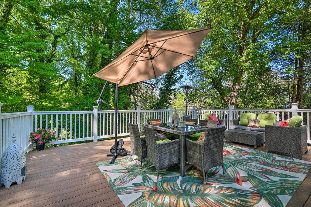 a patio with a table and chairs and an umbrella at Adorable Beach Cottage with Hot Tub and Tropical Bar! in Chesapeake Beach