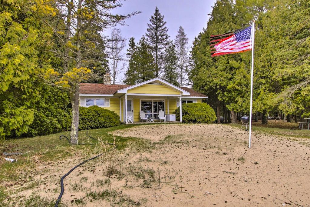 une maison arborant un drapeau américain dans la cour dans l'établissement Cozy Baileys Harbor Cottage on Lake Michigan!, à Baileys Harbor
