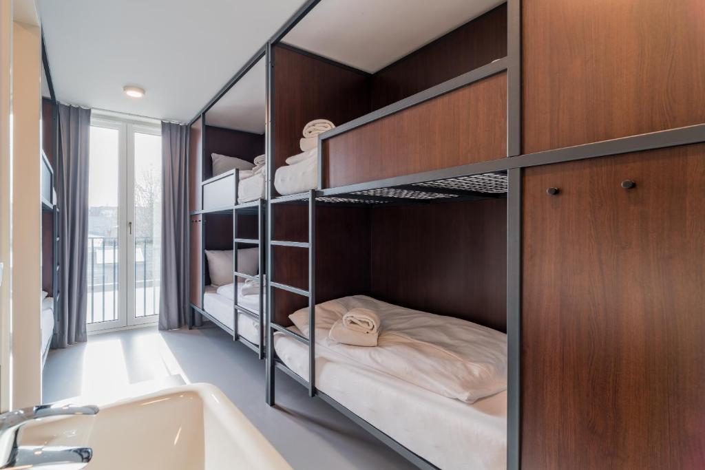 Zimmer mit Etagenbetten, einer Badewanne und einem Waschbecken in der Unterkunft Nena Hostel Berlin in Berlin