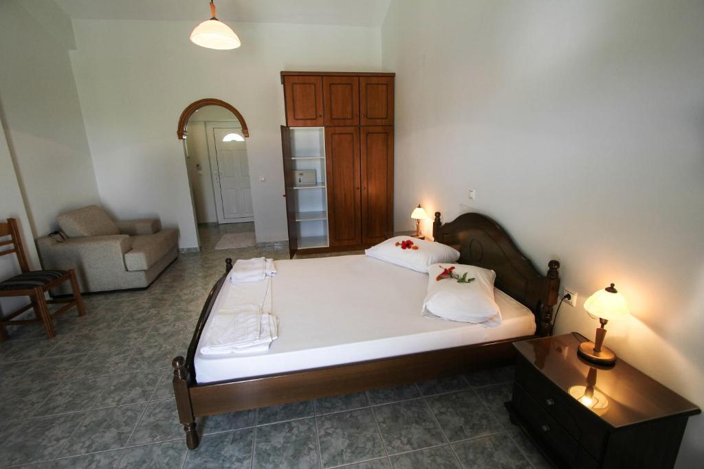 a bedroom with a large bed and a living room at Hotel Villa Basil in Tsilivi