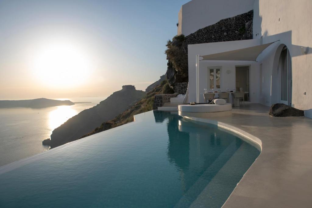 a swimming pool with a view of the ocean at Villa Dio - An Iconic Villa Above Caldera in Firostefani