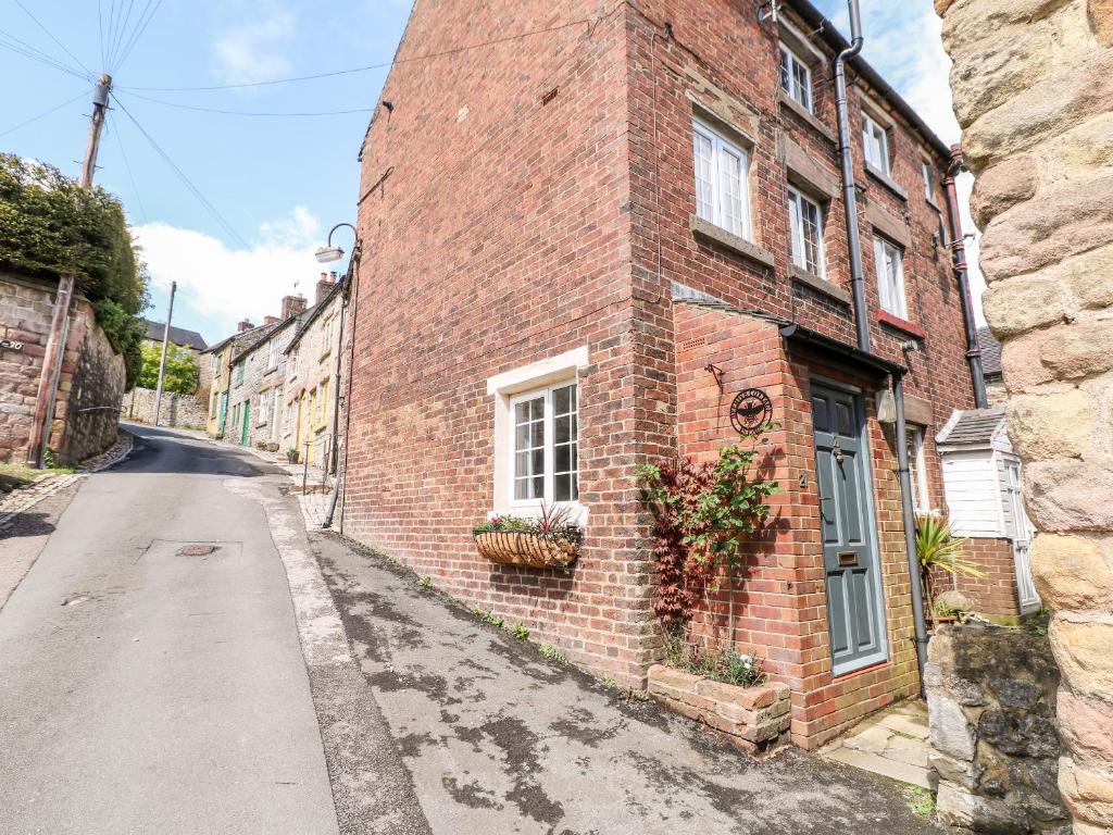 a brick building with a window on a street at Beehive in Matlock