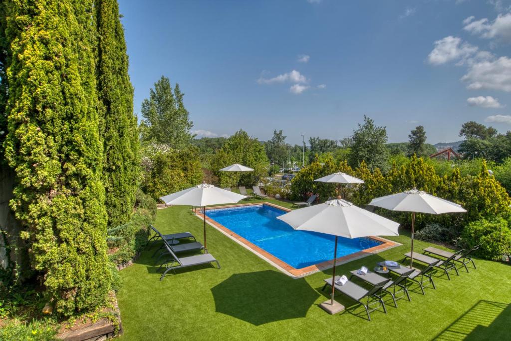 Una vista aérea de una piscina con sombrillas y sillas. en Hotel Costabella, en Girona
