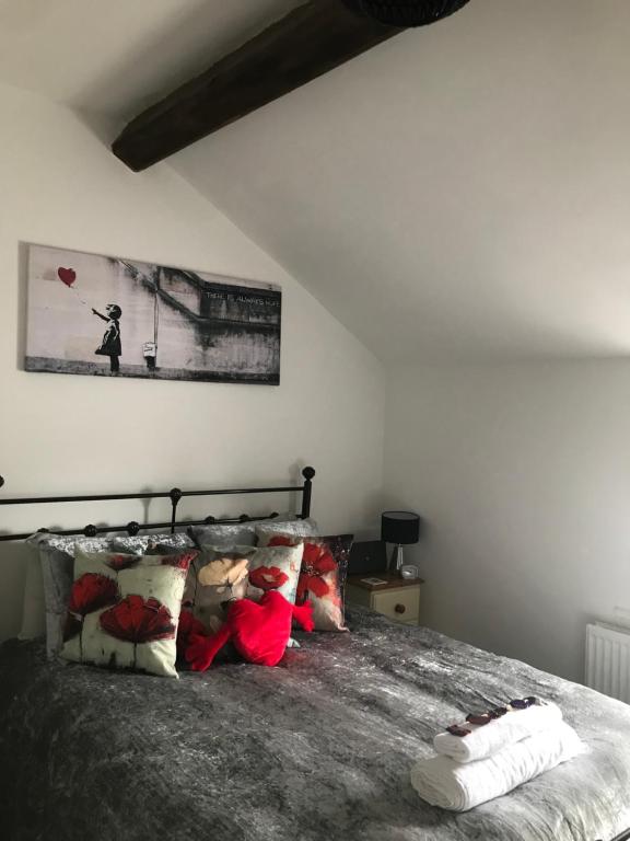 une chambre avec un lit avec des oreillers dessus dans l'établissement Rhos cottage Ruthin, à Ruthin