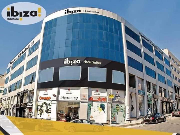 ein großes Gebäude auf einer Straße mit Autos davor in der Unterkunft Ibiza Hotel in Amman