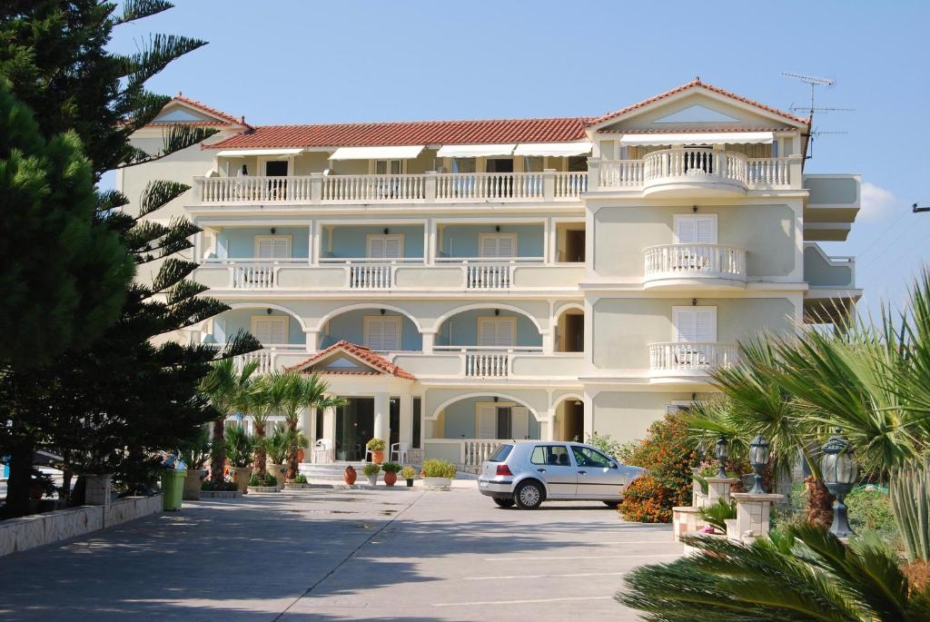 a large white building with a car parked in front at Hotel Villa Basil in Tsilivi